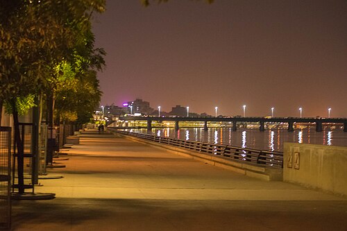 Moving truck in Ahmedabad with the Sabarmati Riverfront skyline, representing relocation services from Gandhidham to Ahmedabad.